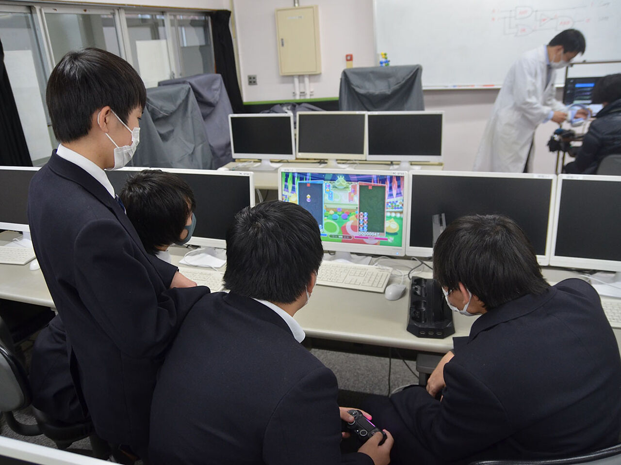 4人の生徒がパソコンを見てゲームをしている画像