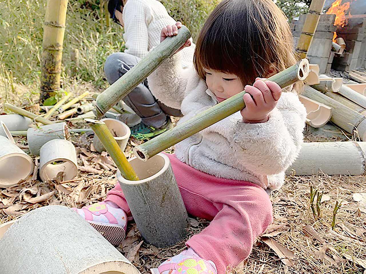 子どもが竹で何かを作っている画像