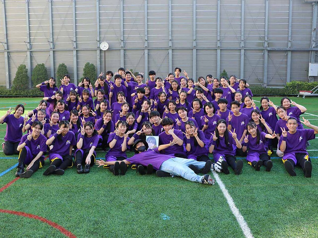 紫のTシャツを着ているダンス部の部員たちの集合写真