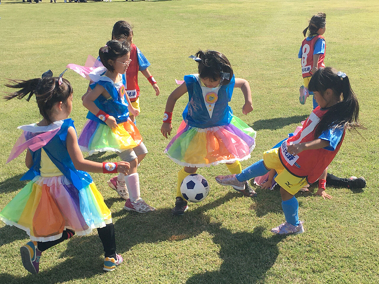 女の子がコスチュームを着てサッカーをしている画像