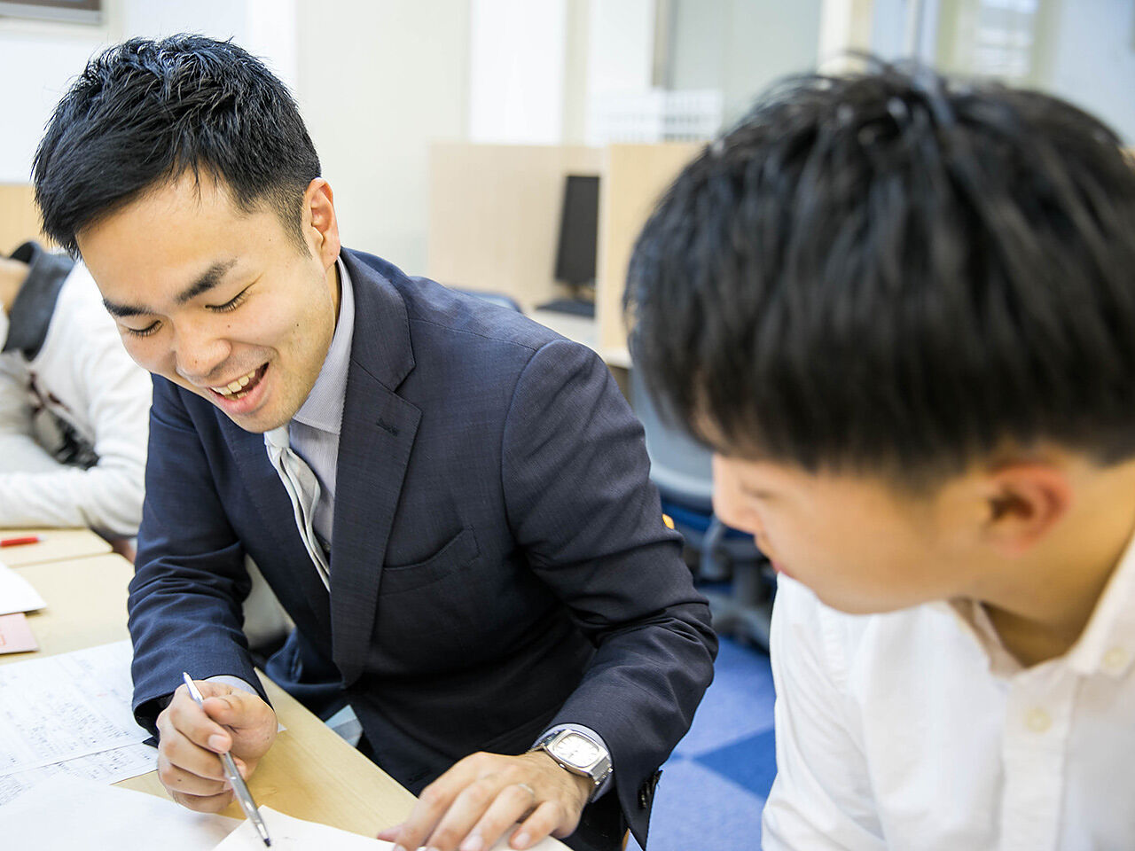 男性講師が生徒に指導している画像