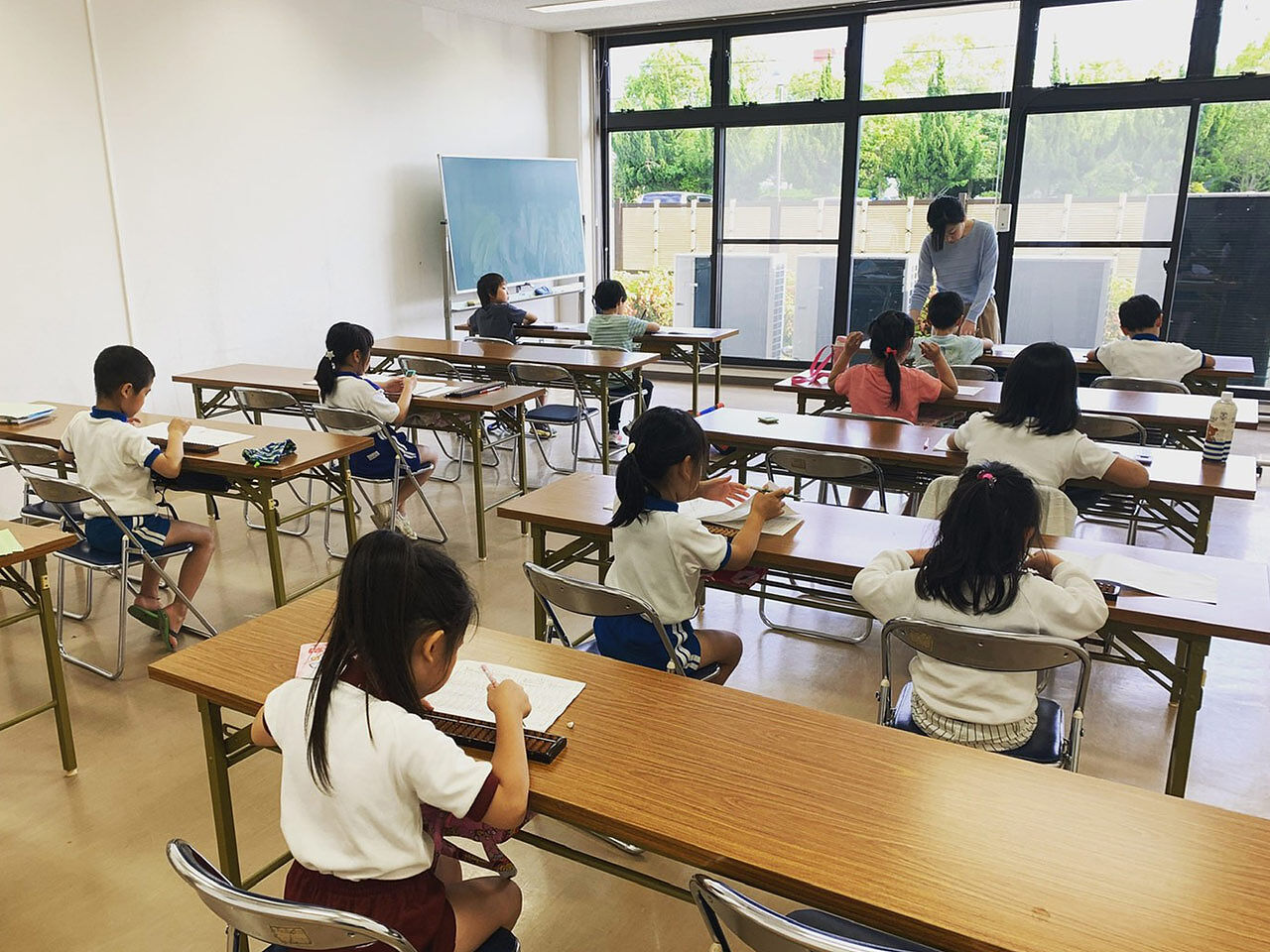 教室で子どもたちが机に並んで勉強している画像