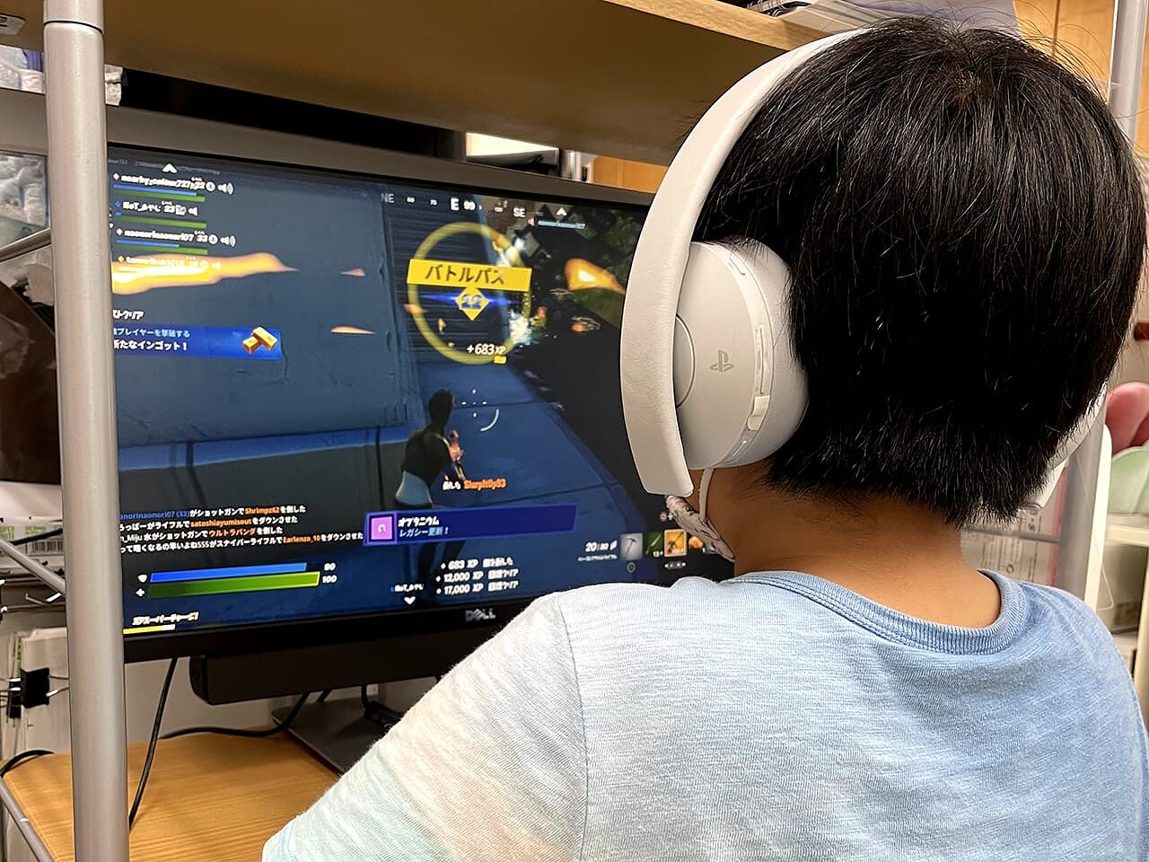 男の子がイヤホンをつけてパソコンでゲームをしている画像