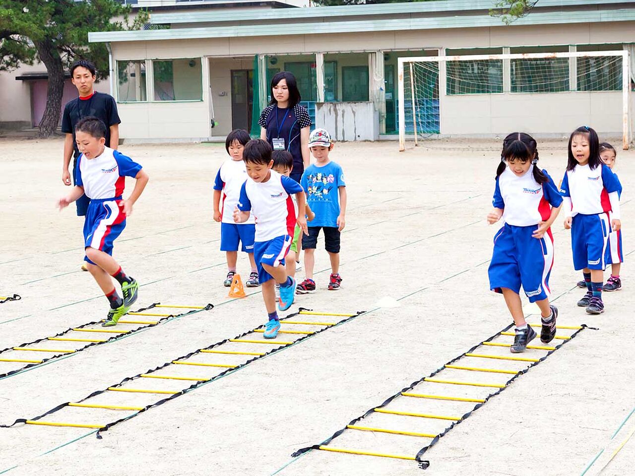 子どもたちが運動場でロープを使って練習をしている画像