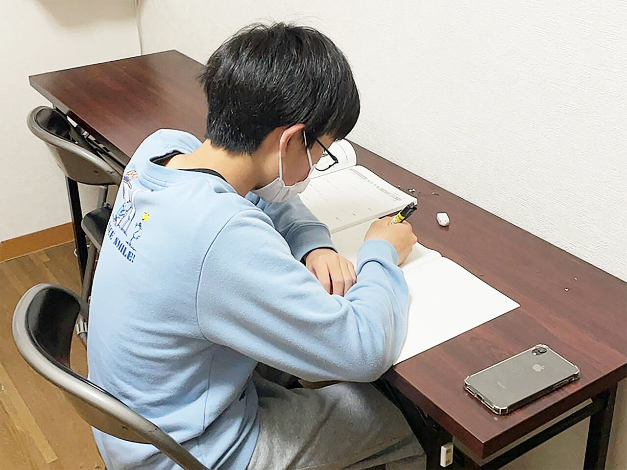 男の子が机に向かって勉強している画像