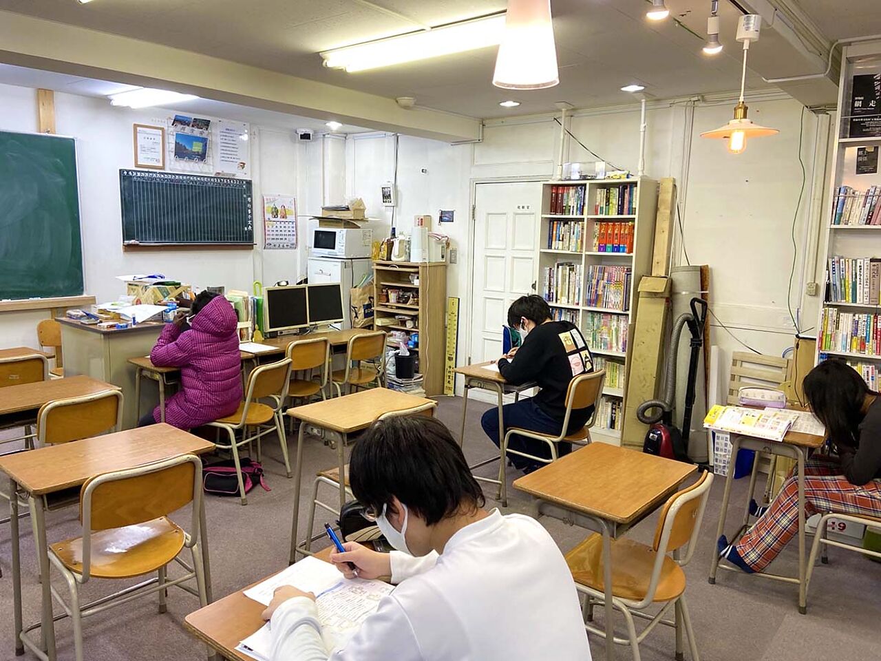 教室内で子どもたちがそれぞれ机に向かって勉強している画像
