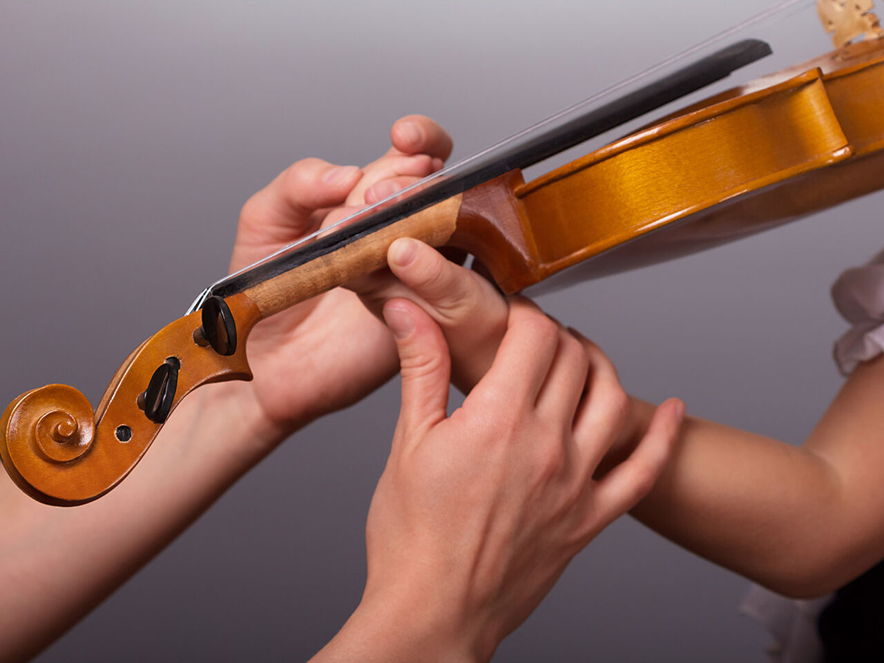 ヴァイオリンの指導を受けている手のアップ画像