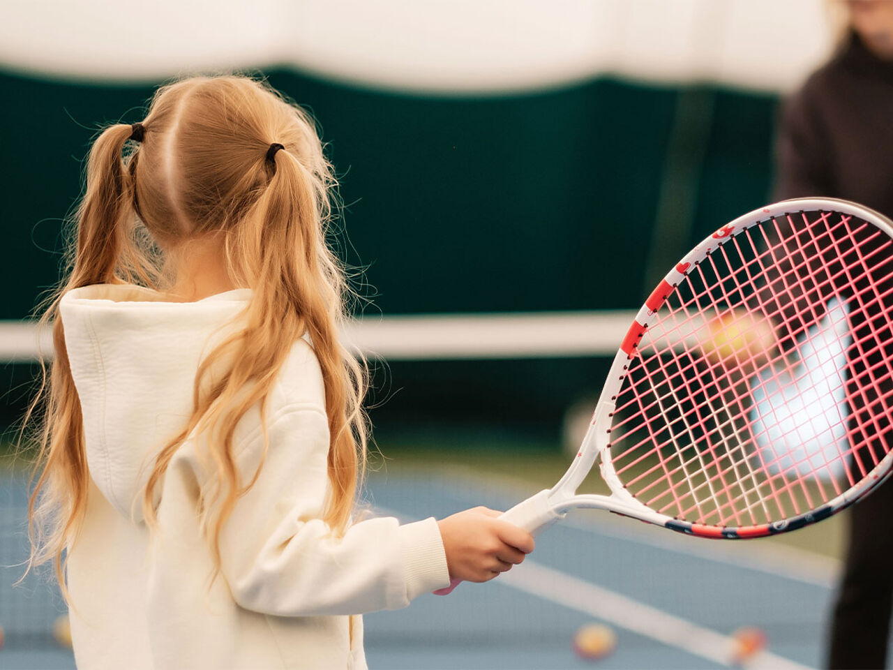 女の子がコートでテニスをしている画像