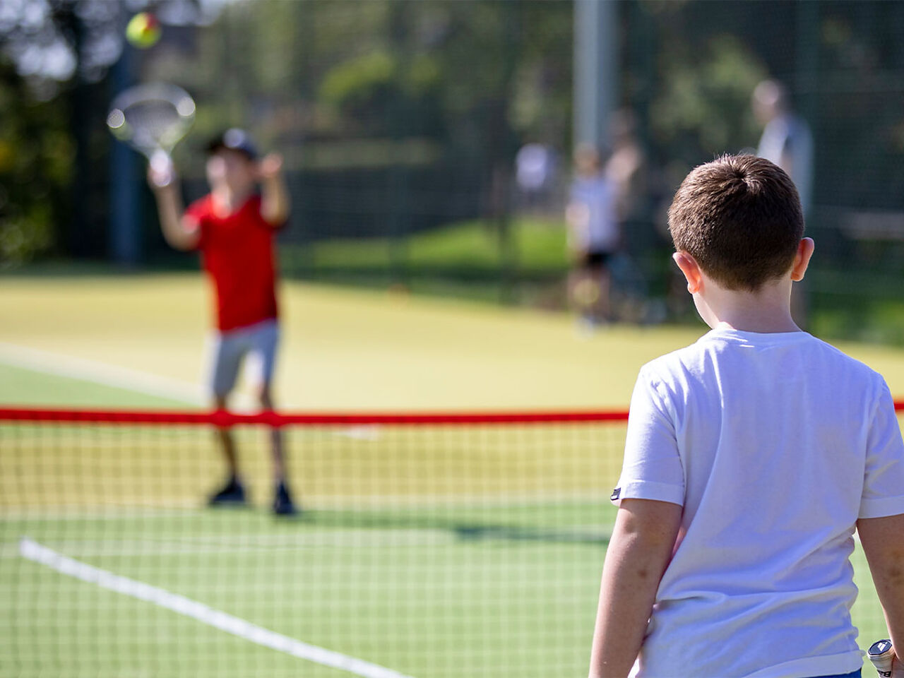 外で男の子2人がテニスをしている画像