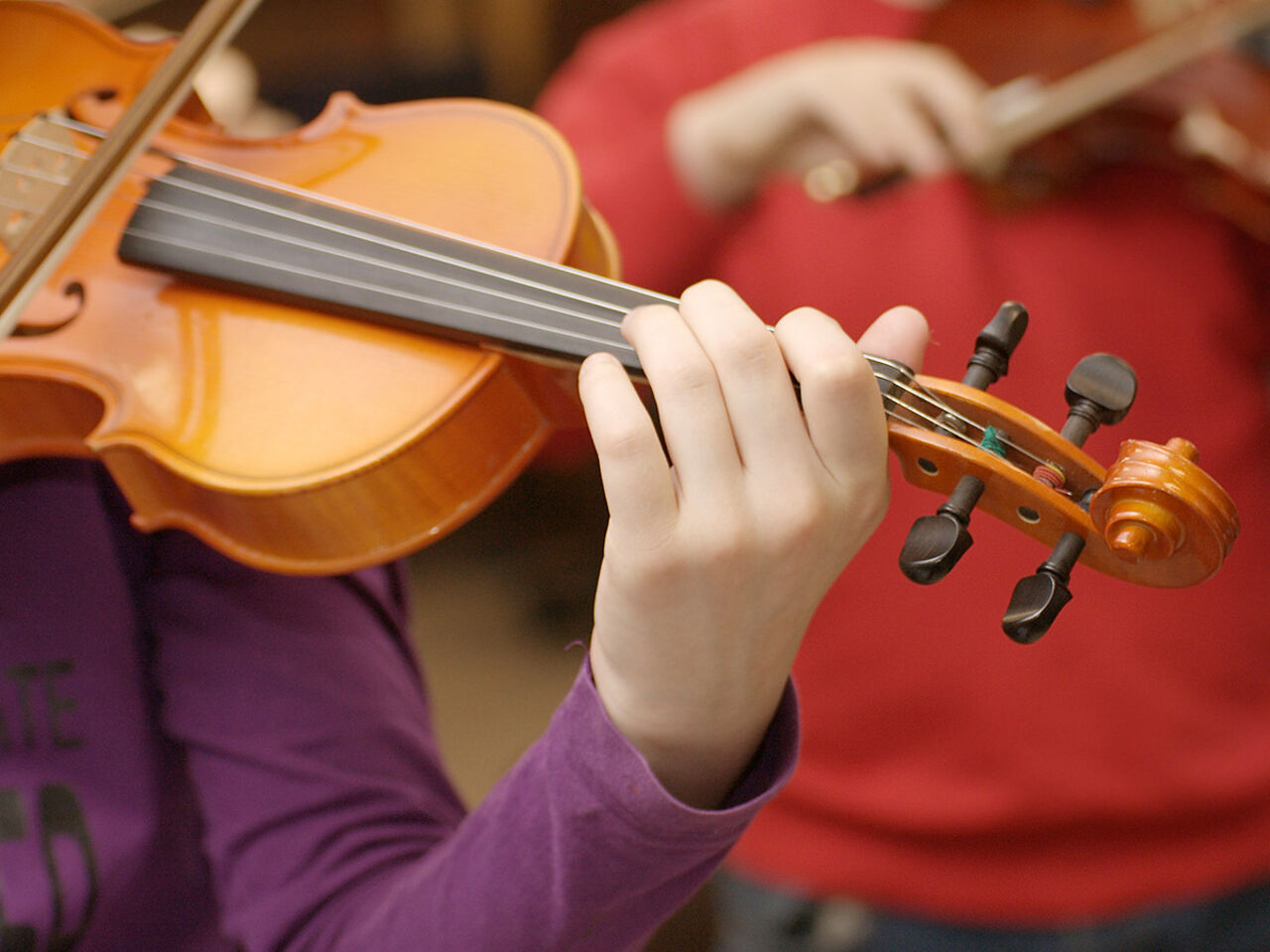 子ども2人がバイオリンを弾いている画像
