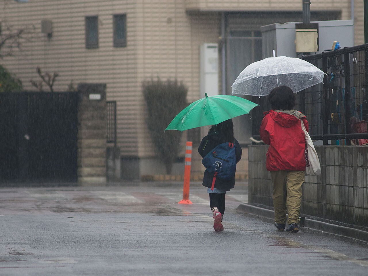 子ども2人が傘をさして帰っている画像