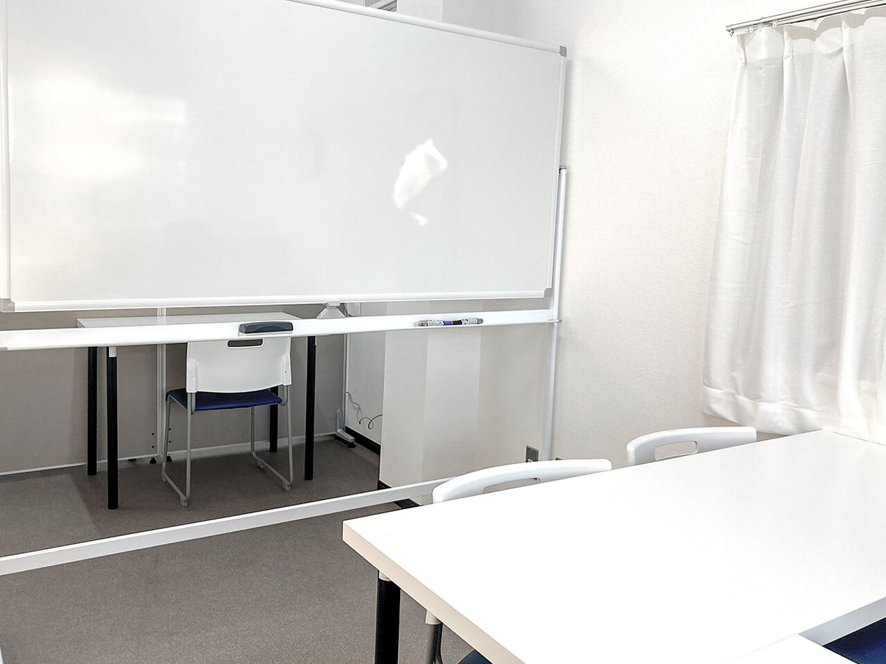 教室内にホワイトボードと机が置いてある画像