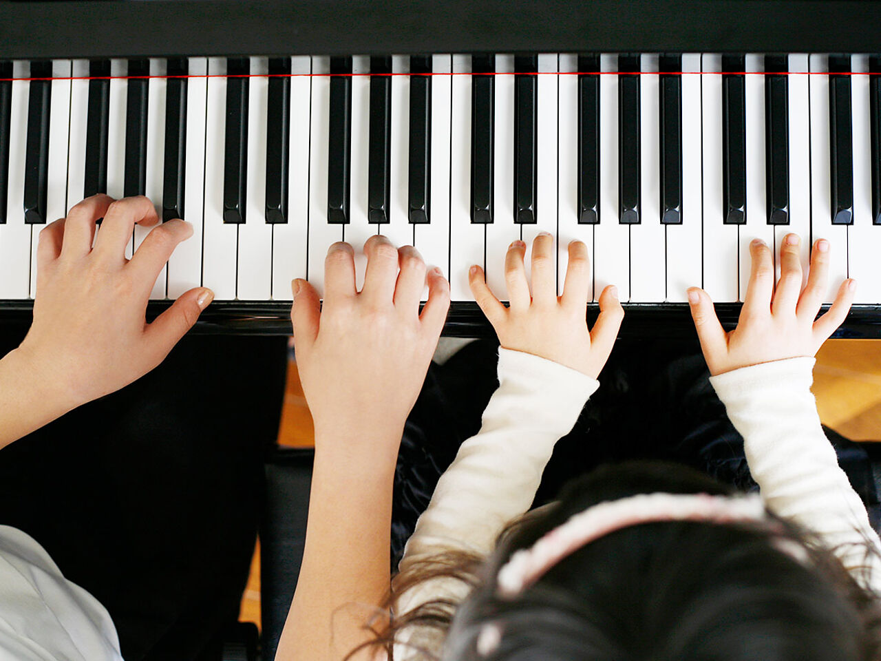 先生と子どもがピアノを弾いている手のアップ画像