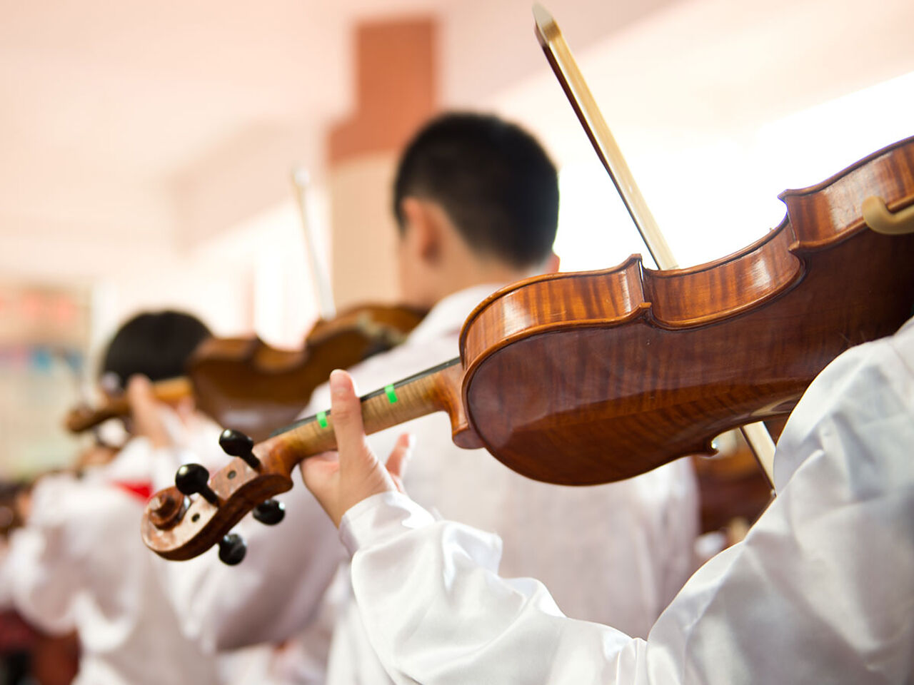 子どもたちが並んでバイオリンを弾いている画像