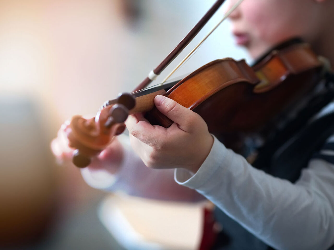 子どもがバイオリンを弾いている画像
