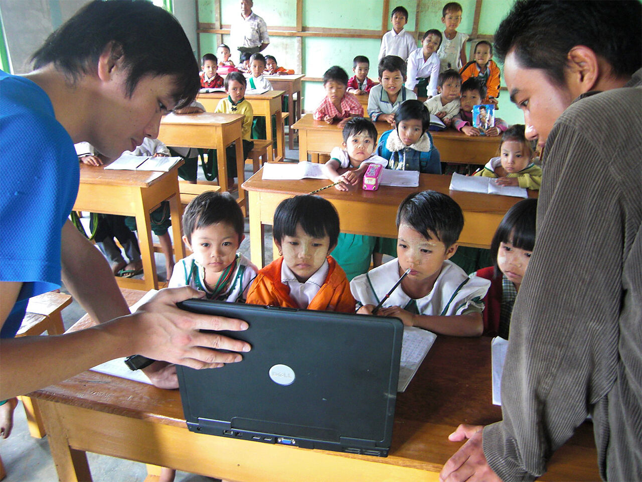 ミャンマーで子どもたちにパソコンを見せている様子の画像