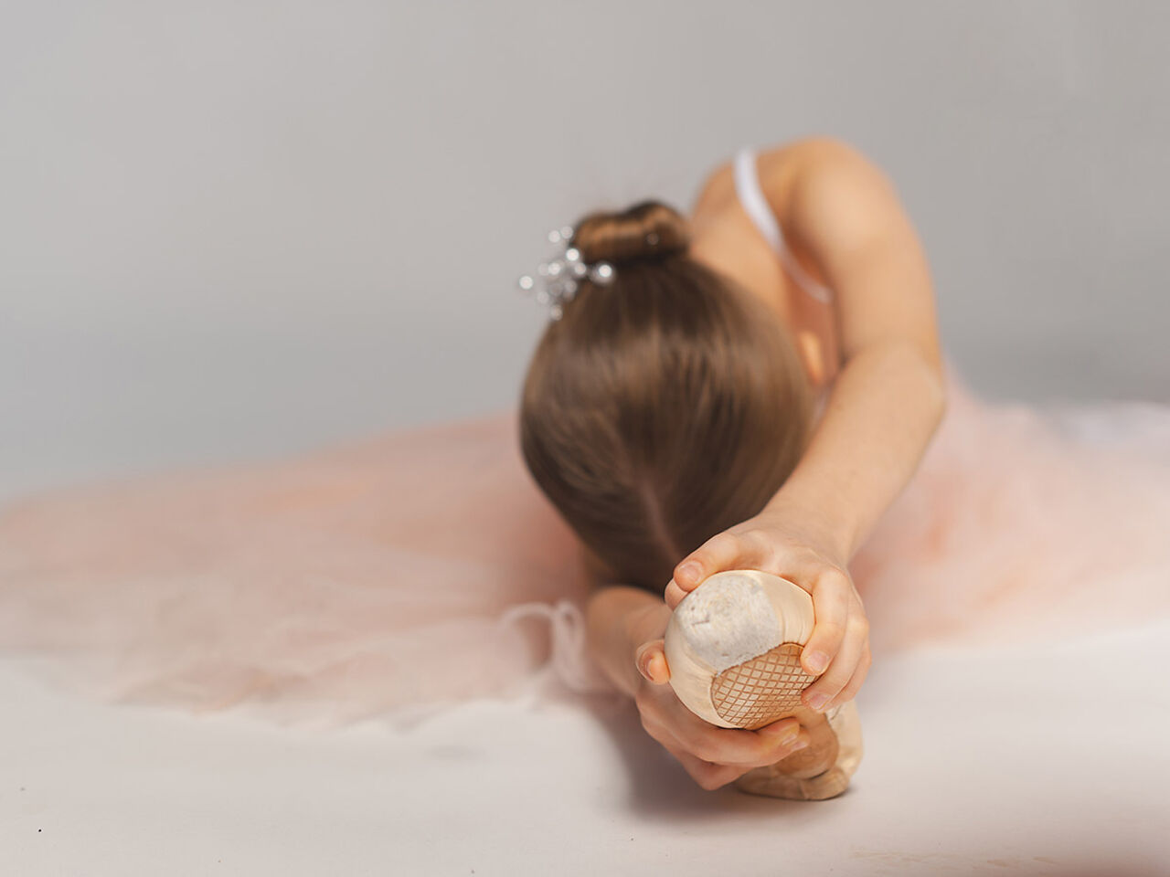 バレエの衣装を着た女の子が柔軟体操をしている画像