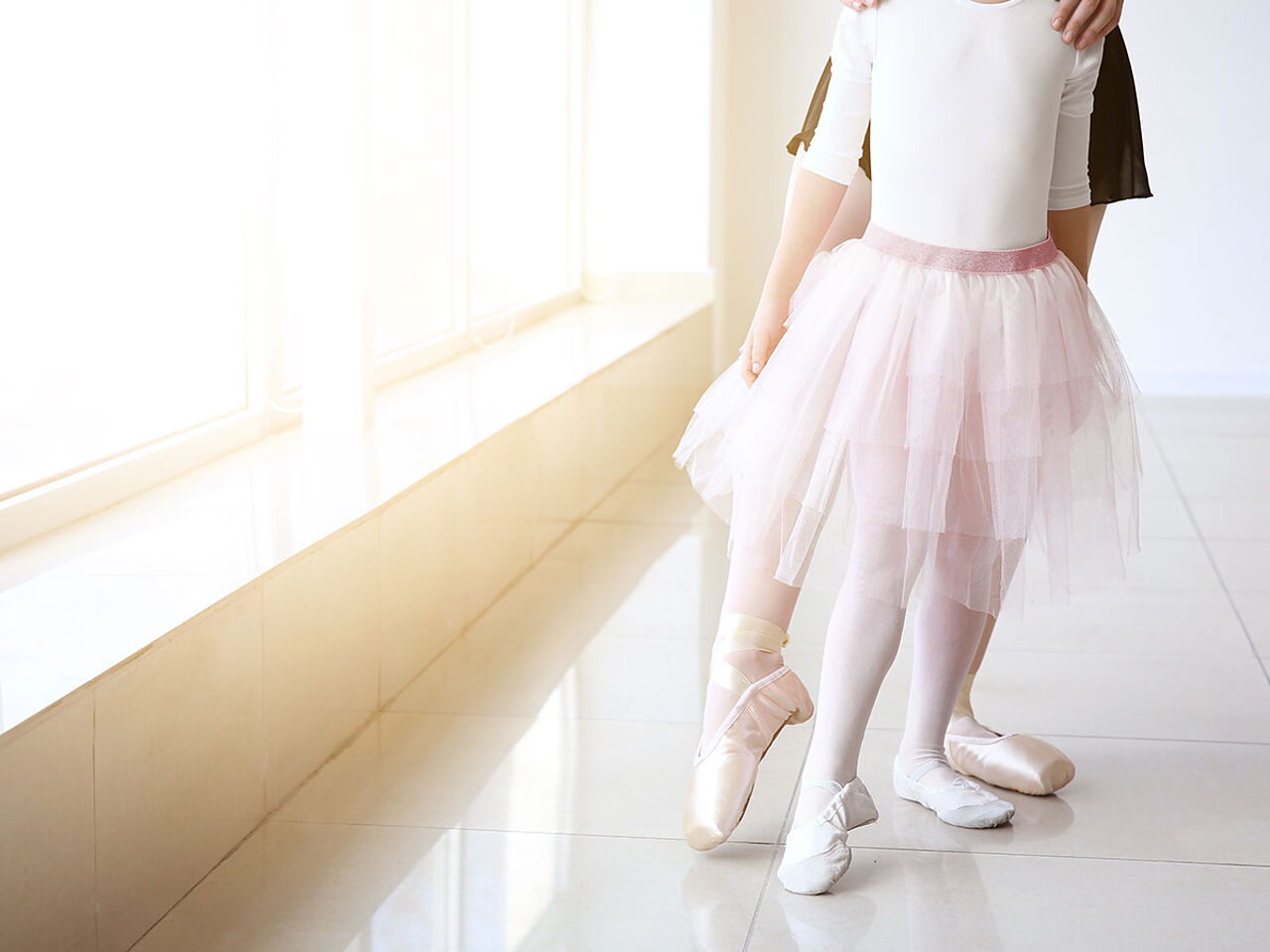 女の子がコーチにバレエの指導を受けている画像