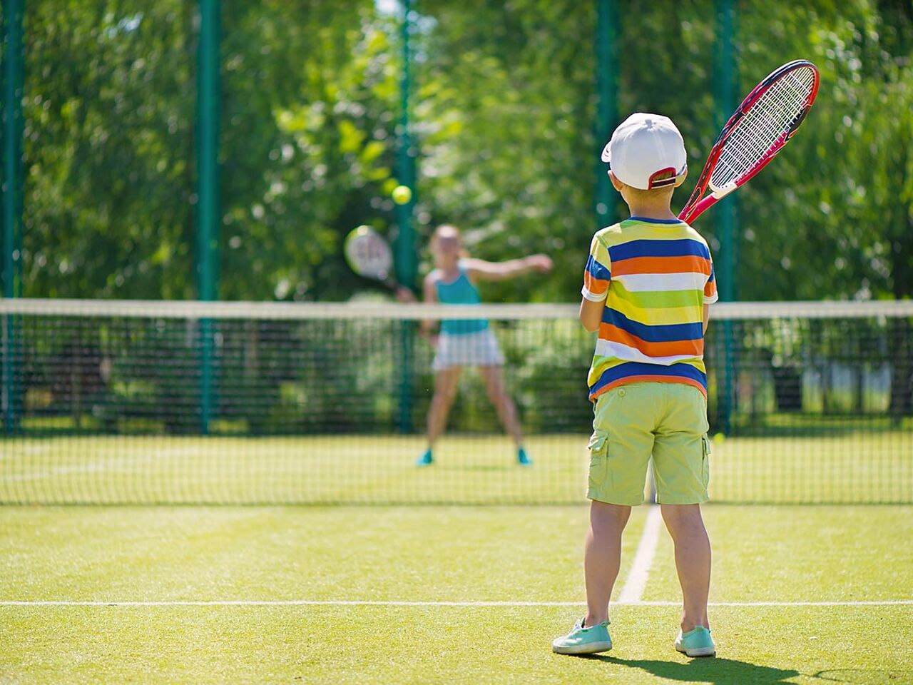 男の子と女の子がテニスをしている画像