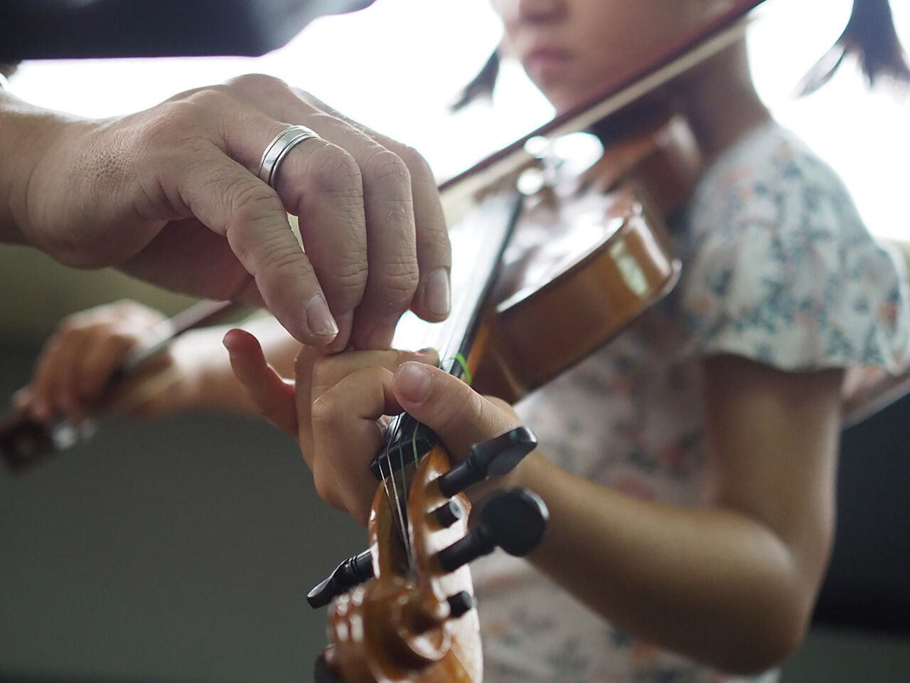 女の子がバイオリンの指導を受けている画像