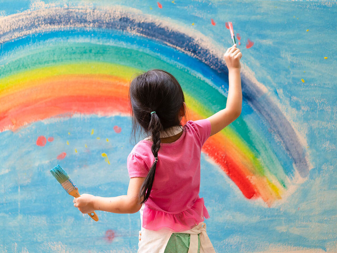 虹の絵を描いている女の子