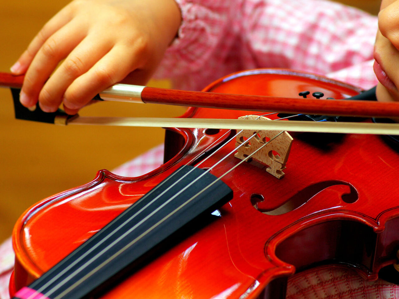子どもがバイオリンを弾いている手のアップ画像