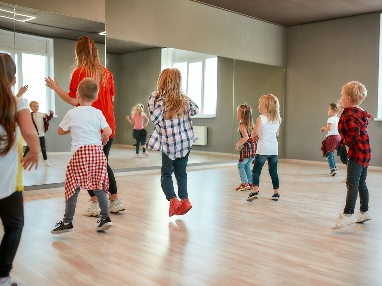 子どもたちがスタジオの鏡の前でダンスの練習をしている画像