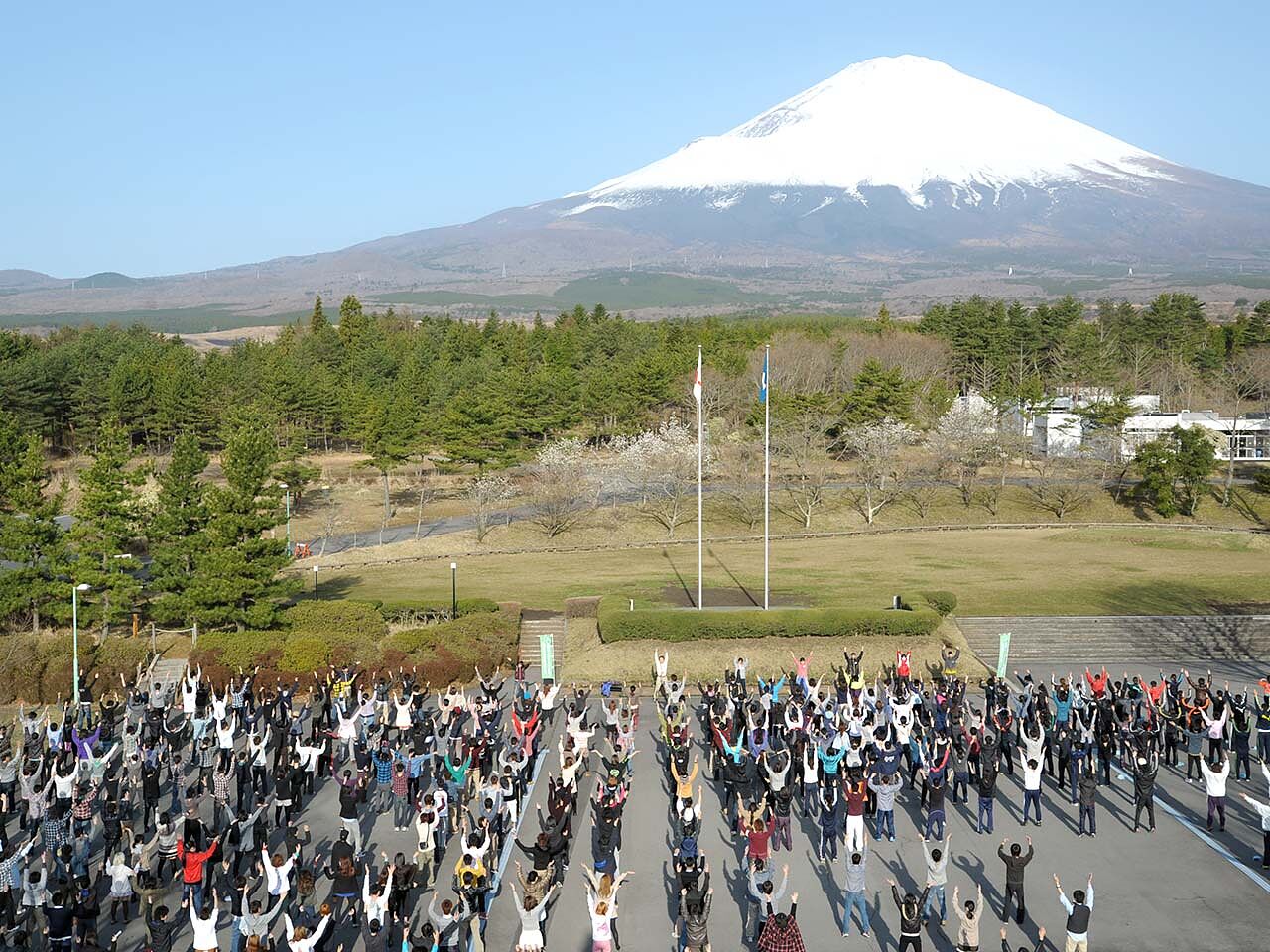 富士山が見える広場でたくさんの人が体操をしている画像