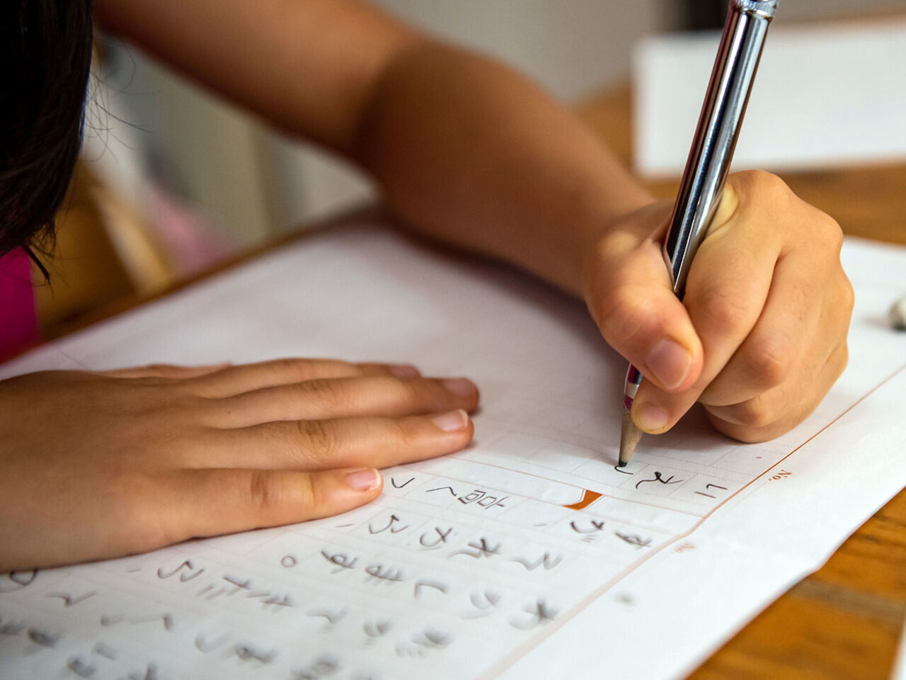 子どもが鉛筆で文字の練習をしている画像
