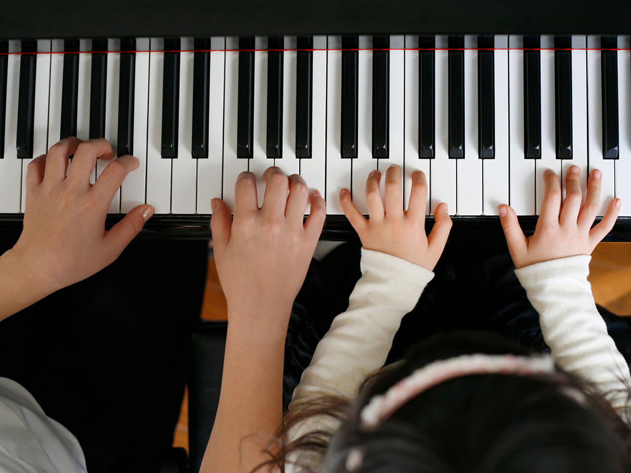 大人と子どものピアノ連弾の画像