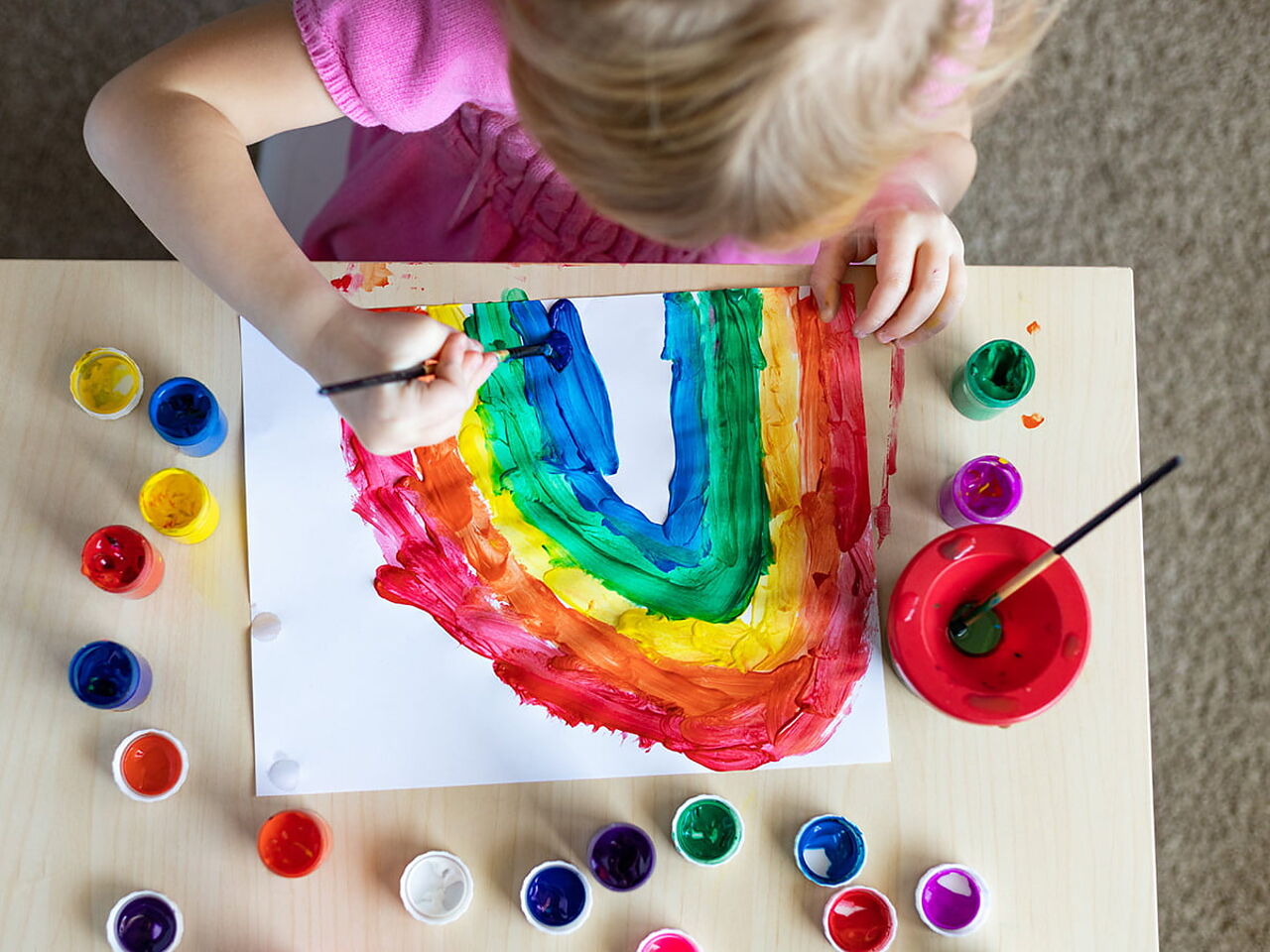 女の子が絵の具で虹を描いている画像