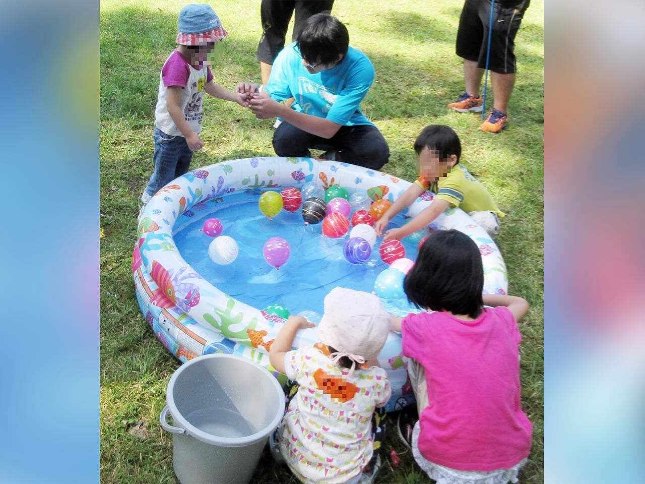 子どもたちがプールに浮かべたボールで遊ぶ画像