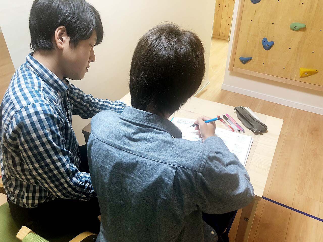 井上さんが子どもに勉強を教えている画像