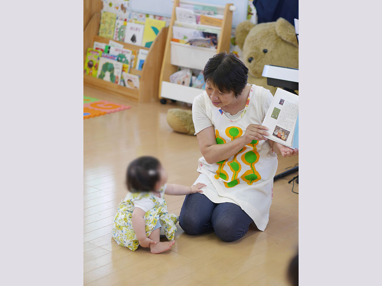 奥野さんが幼児に本を読み聞かせしている画像