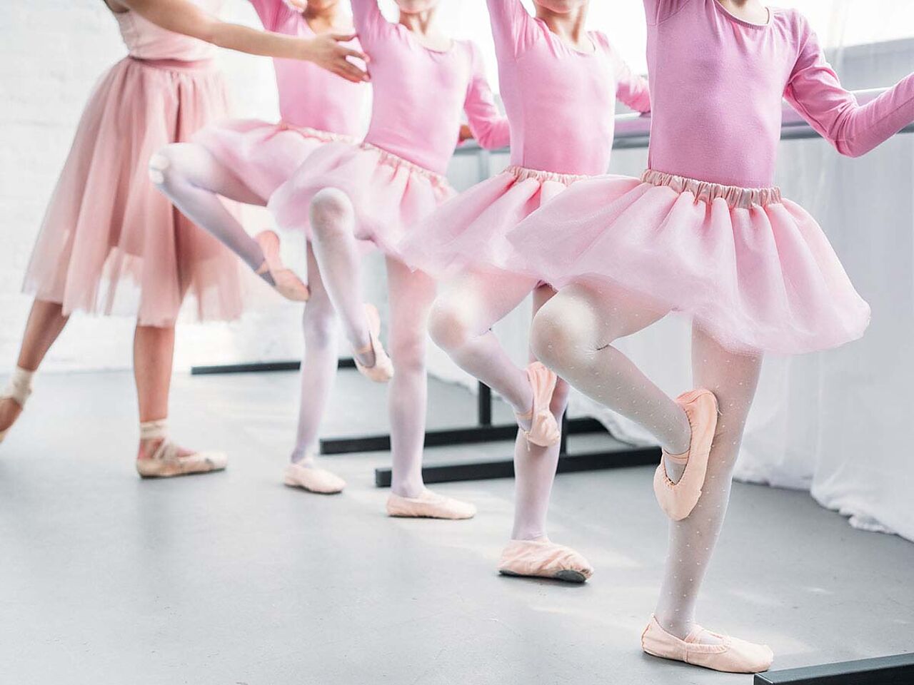 ピンクの衣装を着た子どもたちと講師がバレエの練習をしている画像